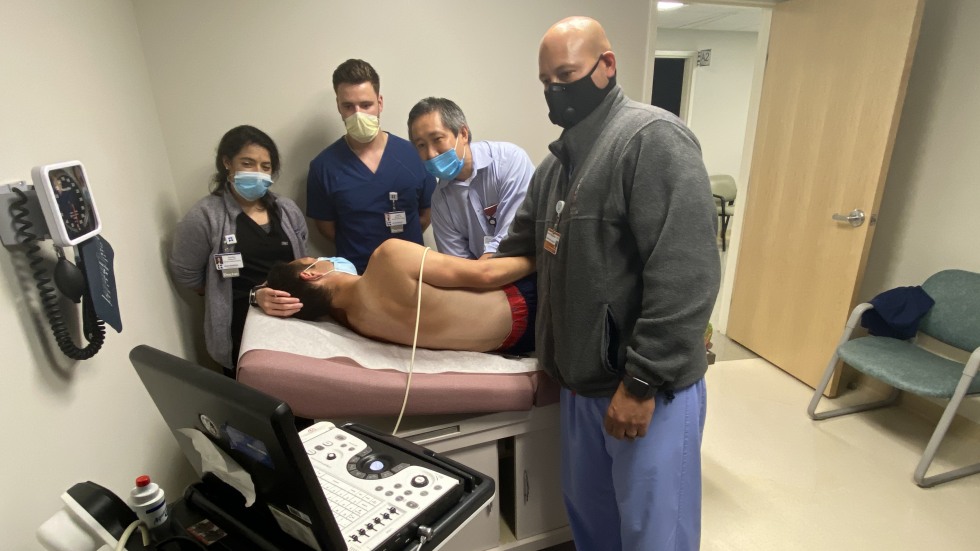 doctors performing ultrasound on patient model 