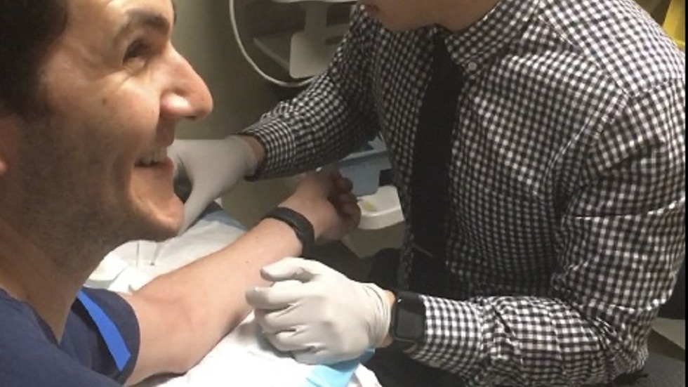 doctor practicing taking blood from medical student